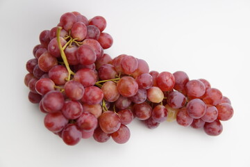Fresh and ripe red grapes isolated in white background. Bunch of raw and juicy grapevines