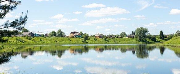 Typical Russian landscape. Russian village on the shore of the lake. Panoramic photo