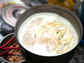 アウトドアでラーメンの麺を湯がくシーン