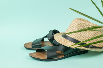 Men's summer hat on black sandals on a blue background.