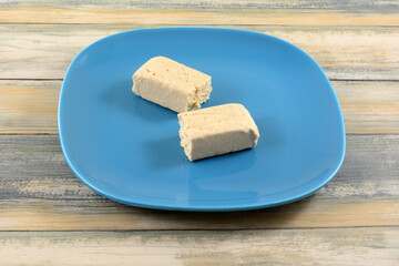 Two pieces of vanilla tahini halvah snack on blue snack plate