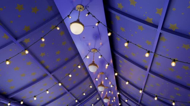 This panning video features a purple tent interior with wizard magic themed canopy  decor, strung lights, and gold stars.