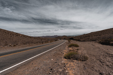 road in the middle of a semi desert valley