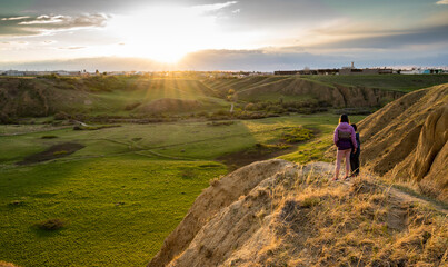Medicine Hat Alberta Canada, May 14 2021: Two children watch a sunset over Seven Persons Coulee while on vacation in a Canadian City.