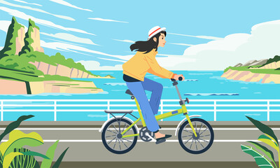 Fototapeta premium a woman rides a bicycle along a seaside road with beautiful sea landscape behind her