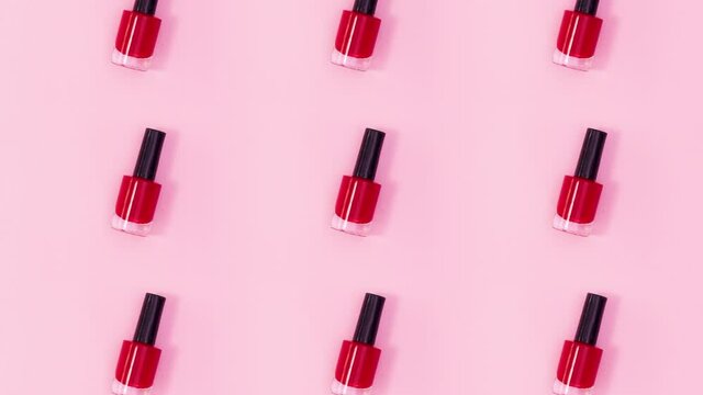 Beauty concept pattern made of nail polishes bottles in same color rotate on bright pink theme. Stop motion