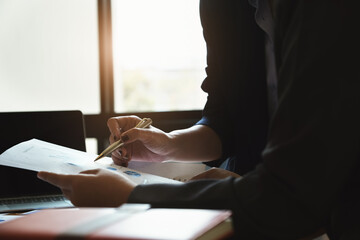 The company employee points to the document to calculate the budget and verify the correctness of the investment.