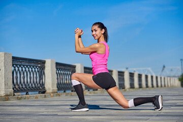 Fitness young woman stretching legs after run. outdoors sport portrait