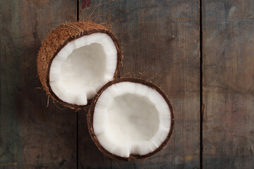 Half cut coconut on a wooden base.