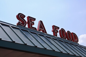 Restaurant Sign Outdoors On Building Roof With Blue Sky
