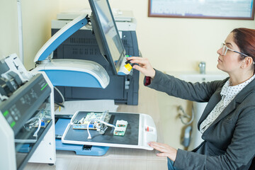 Woman examines microcircuits on a special apparatus for reading the visually impaired.