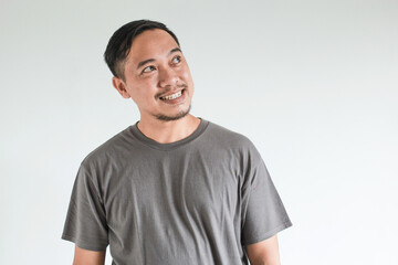 Fototapeta premium Smile and happy face expression of Asian man point to present an empty space of content. Advertising model concept.