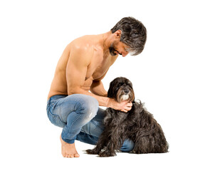 Fit athletic shirtless man bending down caressing his dog