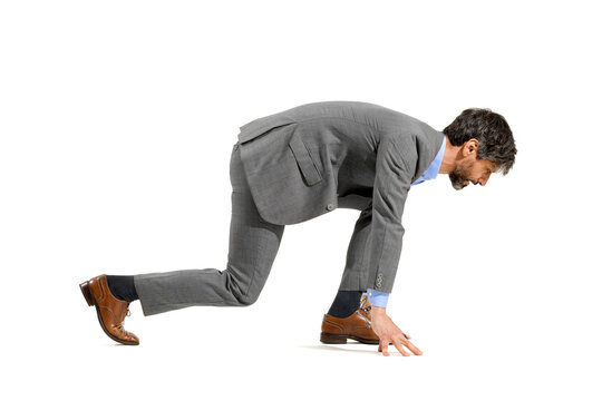 Stylish businessman in suit in the starter position for a race