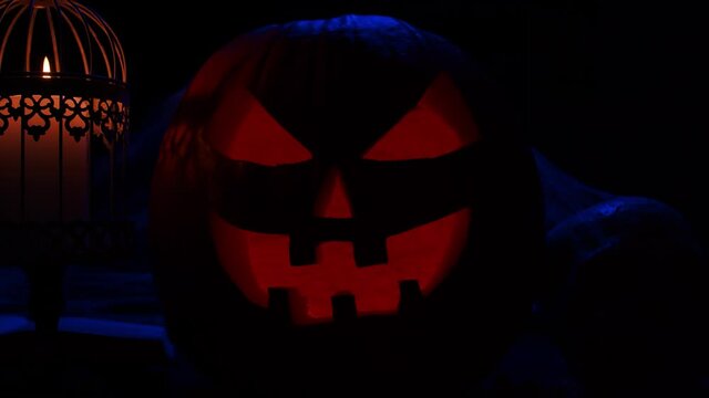Scary laughing pumpkin and an old skull on a dark background. Halloween, witchcraft and magic.
