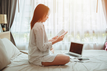 Girl teen read a book self education or working at home during covid self quarantine. women reading a book at bed in the morning.