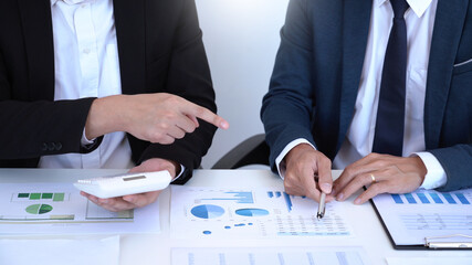 Business concept a couple of business partners calculating annual income and expense for creating the next financial plan.