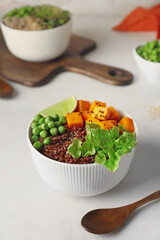 Bowls with tasty quinoa salad on light background