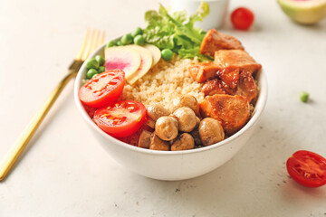 Bowl with tasty quinoa salad on light background, closeup
