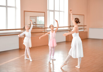 Obraz premium Little ballerinas training with coach in dance studio