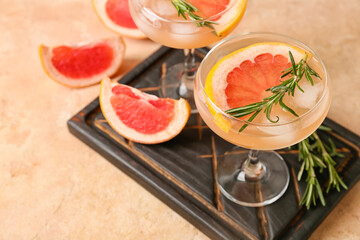 Glasses of tasty grapefruit cocktail on color background