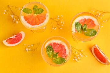 Glasses of tasty grapefruit cocktail on color background