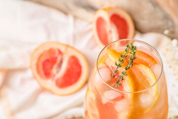 Glass of tasty grapefruit cocktail on table, closeup