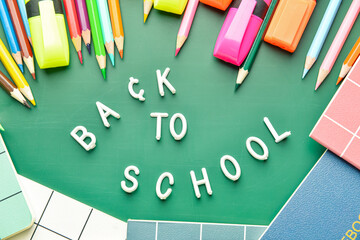 Composition with text BACK TO SCHOOL and stationery on color background