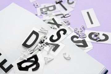 Blank book with letters on color background, closeup