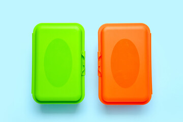 Plastic lunch boxes on color background