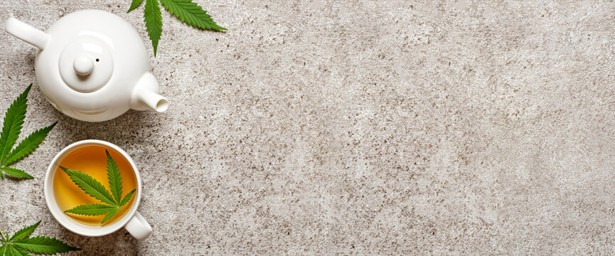 Hemp herbal tea and leaves on gray banner. Calming drink concept