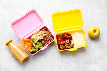 Lunch boxes with tasty food on light background