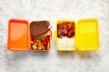 Lunch boxes with tasty food on light background
