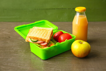 Lunch box with tasty food on table