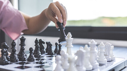Businesswoman holding chess to take down opposing players, Proactive business planning and...