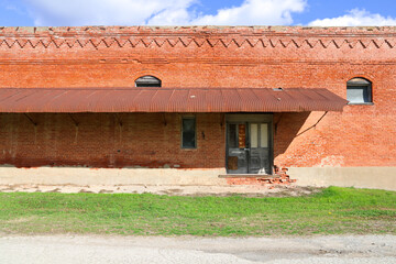 old abandoned deserted rural small town warehouse building with rusting awning roof empty and...