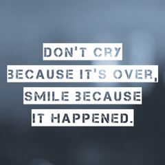 Inspirational motivating quote on blur background, "Don't cry because it's over smile because it happened."