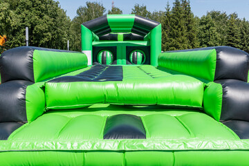 Green children's inflatable entertainment attraction. Obstacle course and maze combined. Festive...