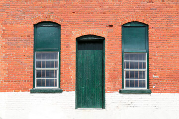 old town village red brick and white painted abandoned factory warehouse store door and windows trimmed in green