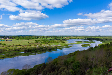 Bird's-eye view: river, fields, village.