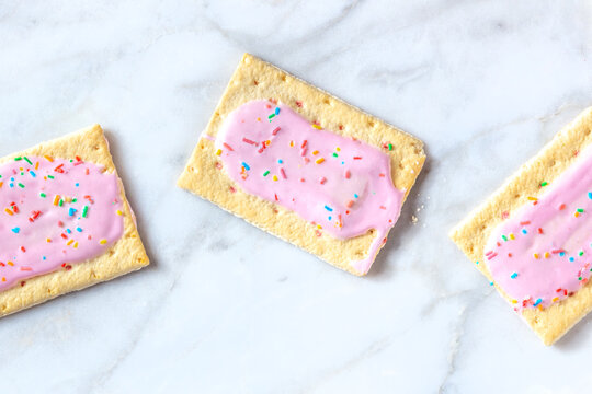 Pop tarts, strawberry toaster pastry, shot from the top on a white marble background