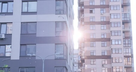 Residential building apartments windows at sun day. Modern building facade. Rent, purchase, sale of new housing concept. Camera moves from top to bottom. Multistory apartment building in urban area
