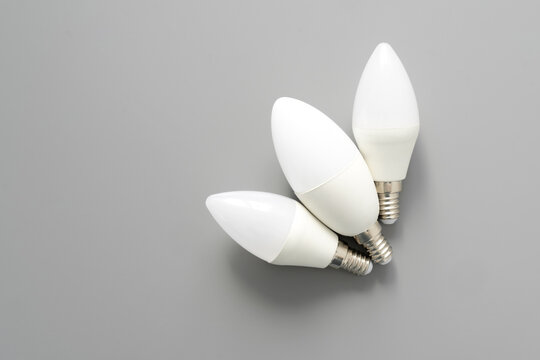 Three Lightbulbs On Gray Background, Close Up