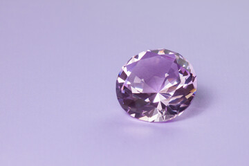 Purple precious gemstone for design gems jewellery. Big diamond crystal on purple background.