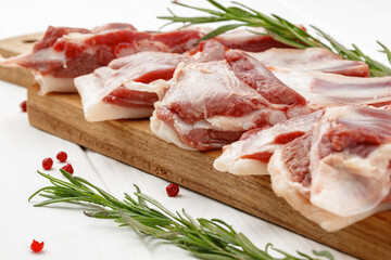 Raw meat ribs on wooden board on white background