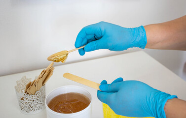 shugaring, the master picks up the paste for hair removal