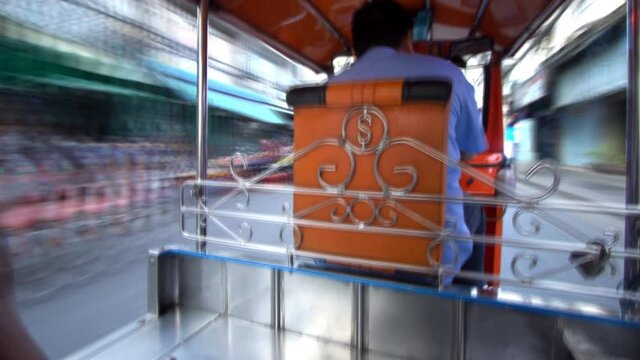High speed Tuk Tuk driving on street in Bangkok, Thailand. A popular three-wheeled taxi transport in Bangkok.
