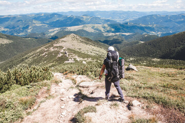 Fototapeta premium young hiker man in mountains. summer trekking path