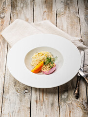 Risotto with seafood. Egg with smoked mackerel pate. Honey orange tomato. Gourmet cuisine. Food photography and styling. Mediterranean Kitchen. Vertical shot. Delicious and healthy eating. Copy space