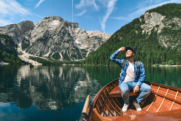 man in big wooden boat at mountain lake